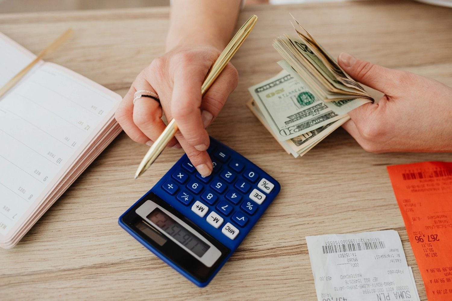 Person calculating something holding currency in hand